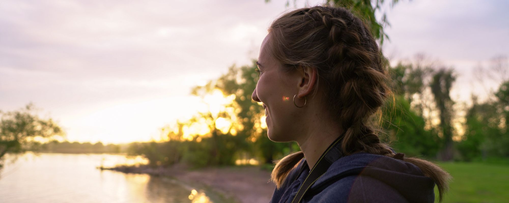 person smiling while looking at the sunset