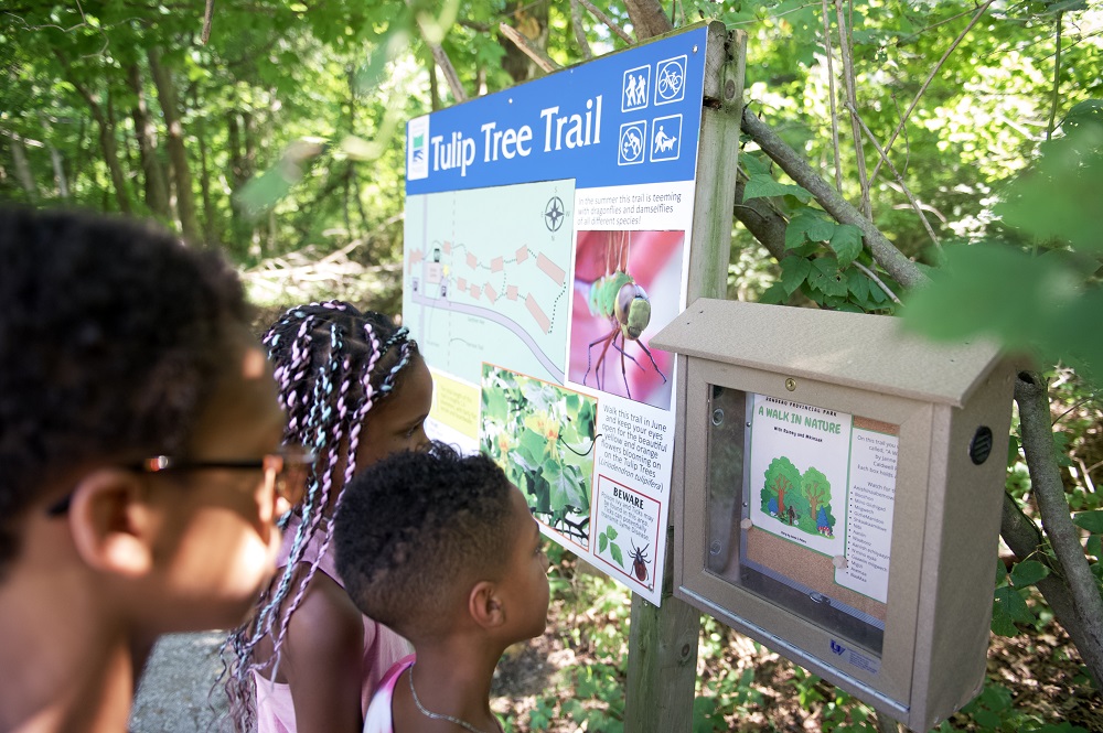 family looking at interpretive sign