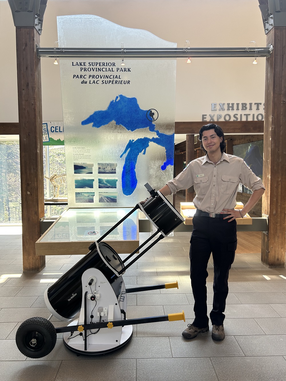 staff in visitor centre, leaning against telescope