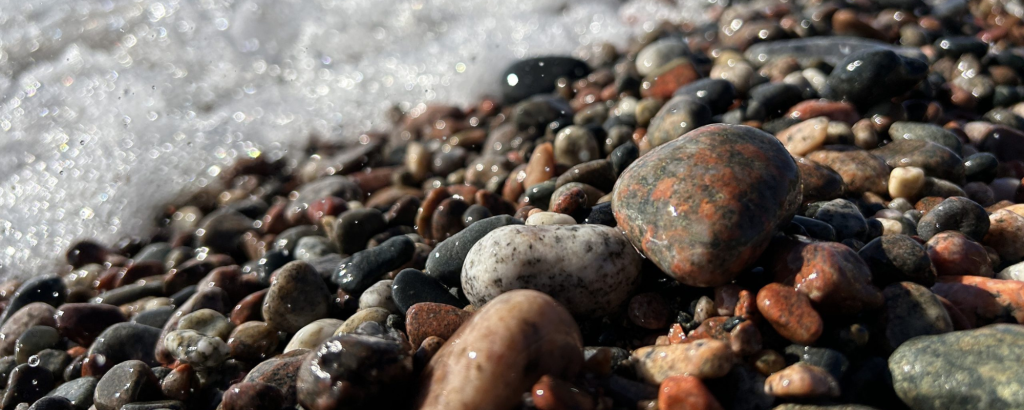 Colourful pebbles at Agawa Bay being splashed by Lake Superior waves, Lake Superior Provincial Park