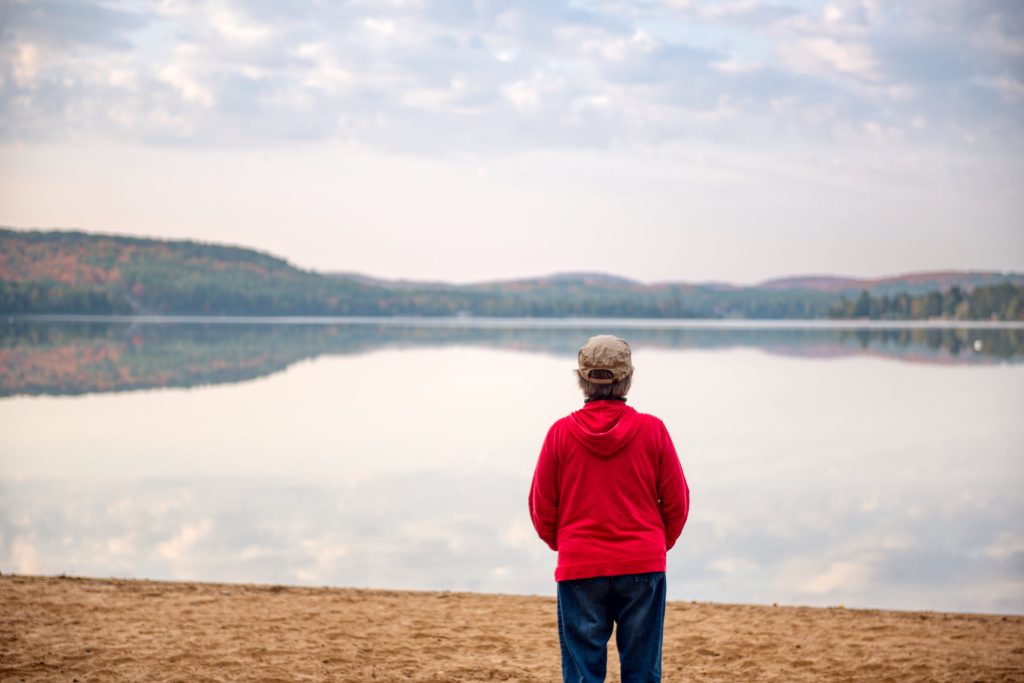 person looking out at fall colours from beach