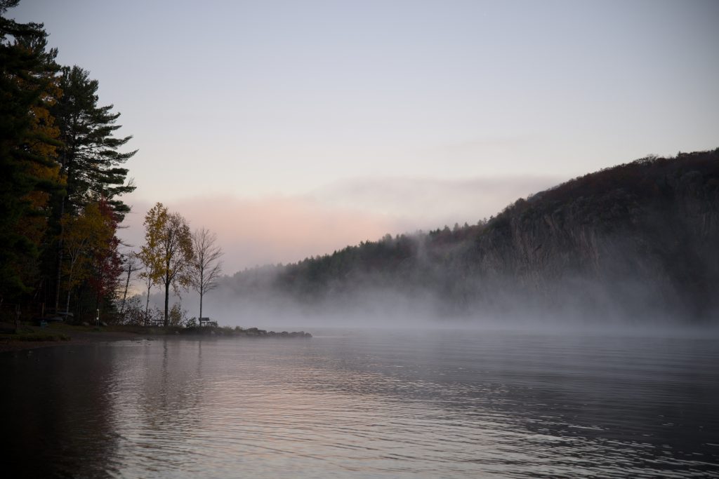 misty view of Mazinaw Rock across lake