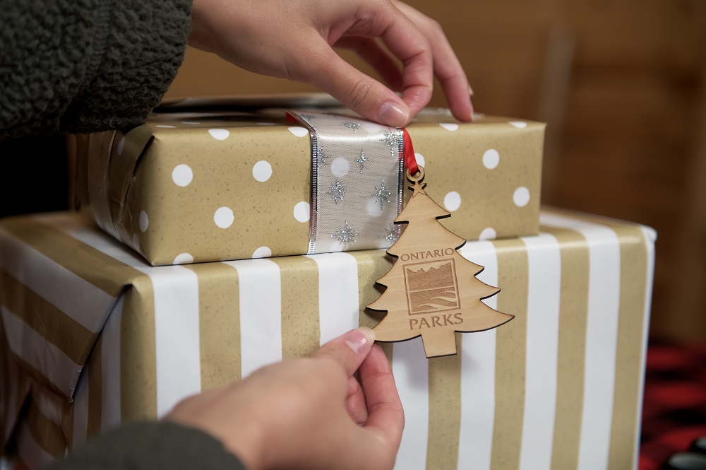 person putting ornament on gifts