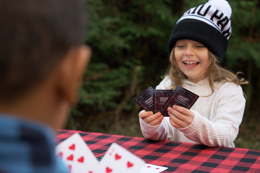 child playing cards with toque on