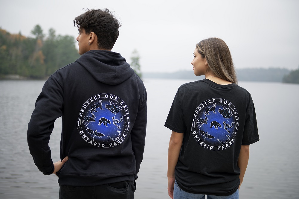 model wearing sweater, model wearing t-shirt, looking out at lake