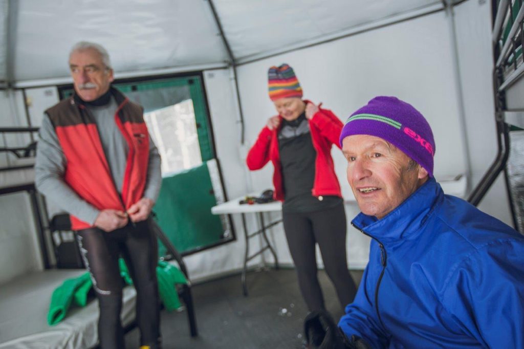 trois skieurs enfilent leurs vêtements d'hiver