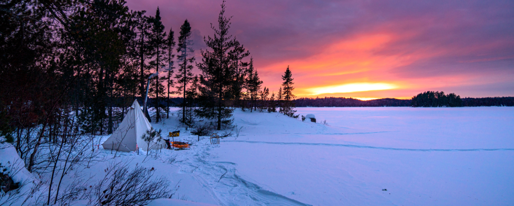 tent in winter landscape at sunset