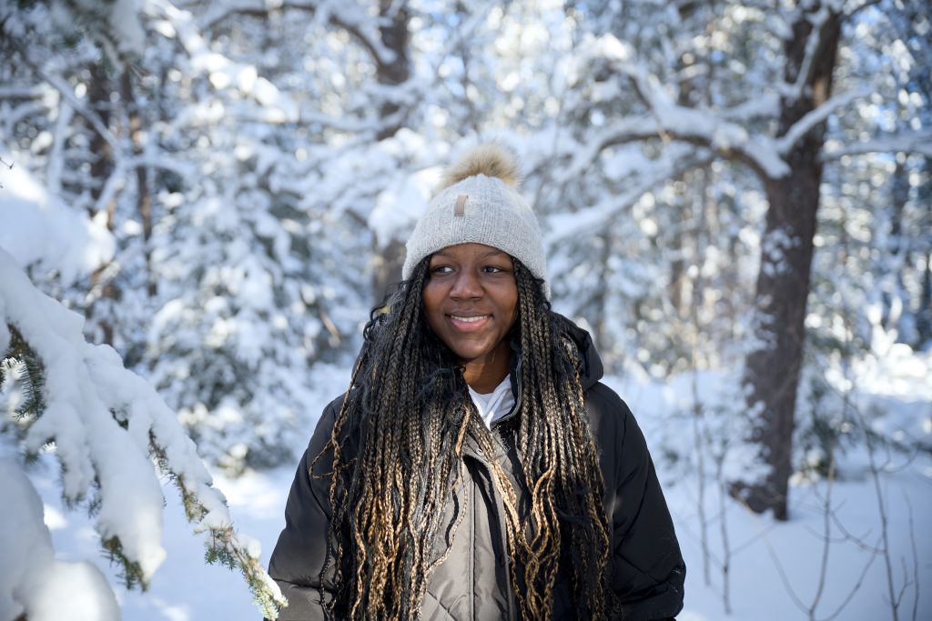 hiker smiling at camera in snowy forest