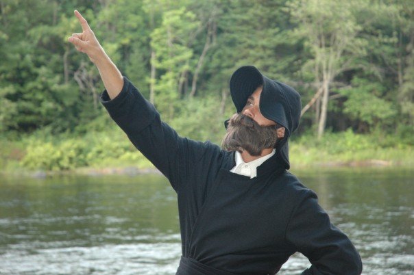 staff dressed up in costume with fake beard, pointing towards sky