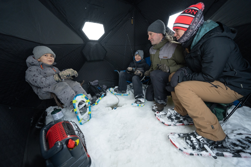 Famille pêchant sur la glace dans une cabane