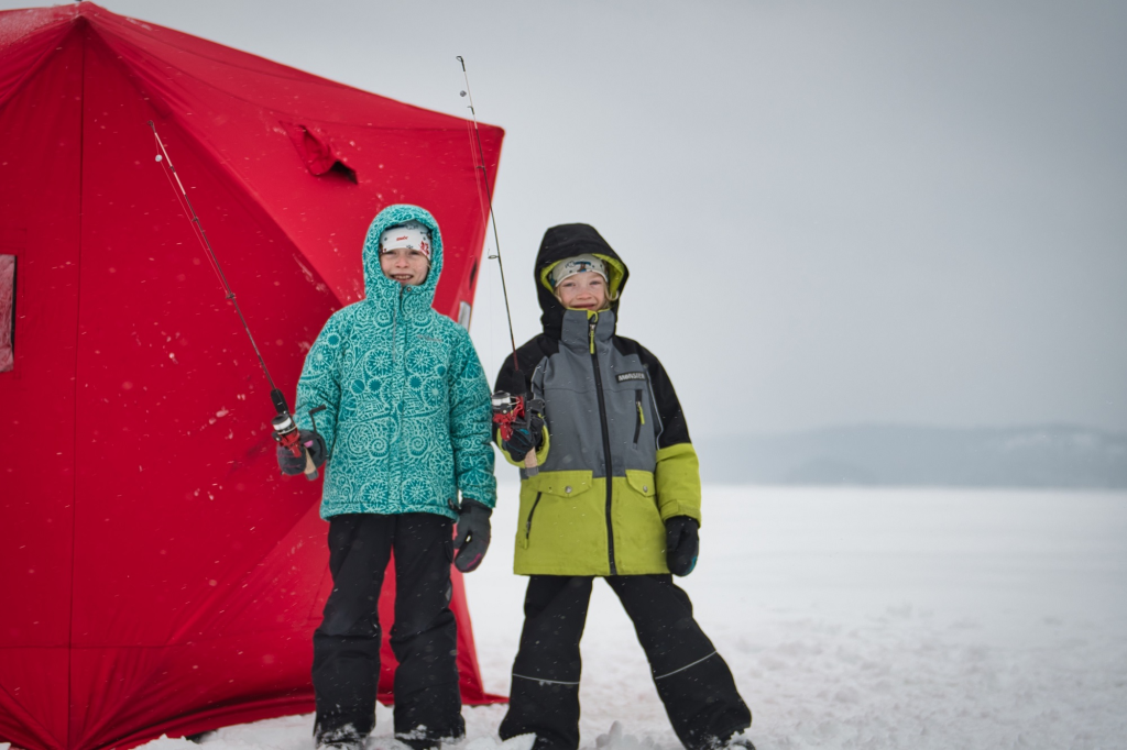 Deux enfants s’apprêtant à pêcher sur la glace