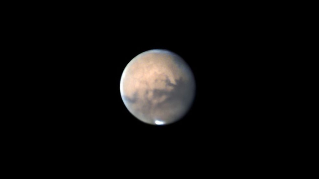 Mars, seen in the black of space. It is a reddish sphere