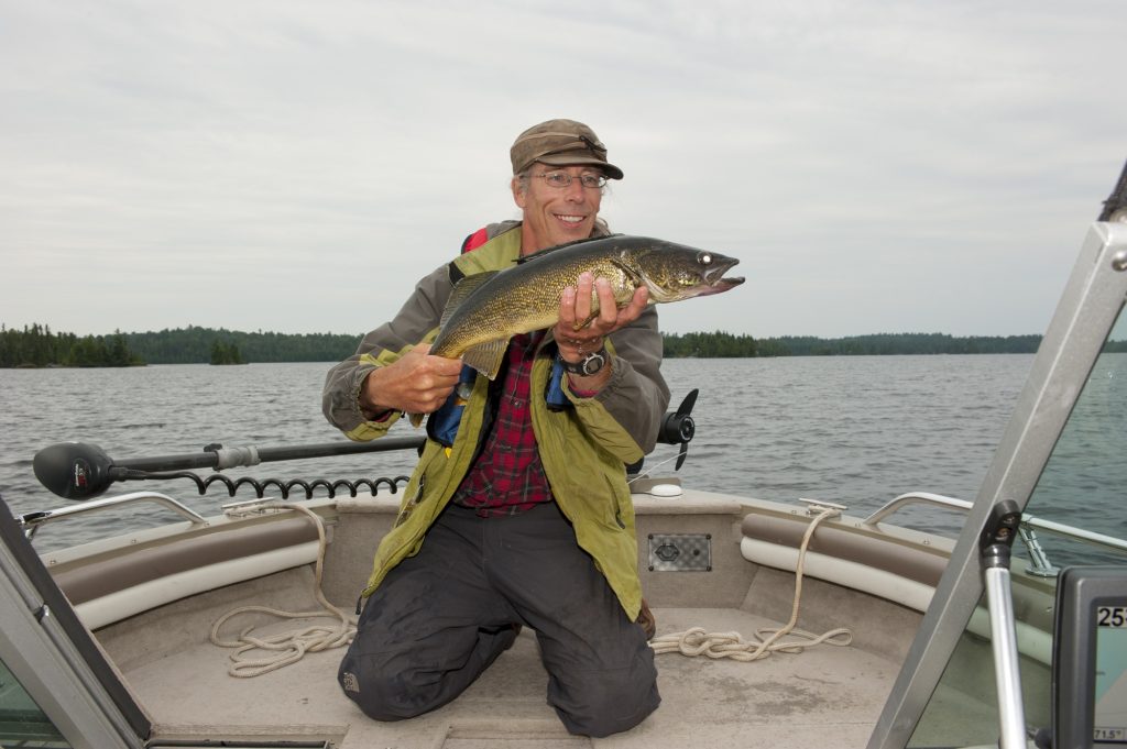 angler holding fish in boat