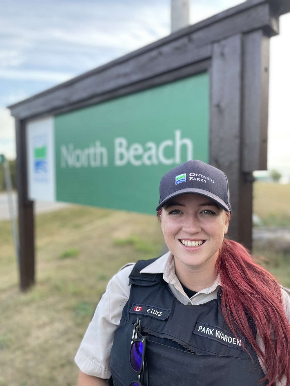 park warden standing in front of North Beach park sign