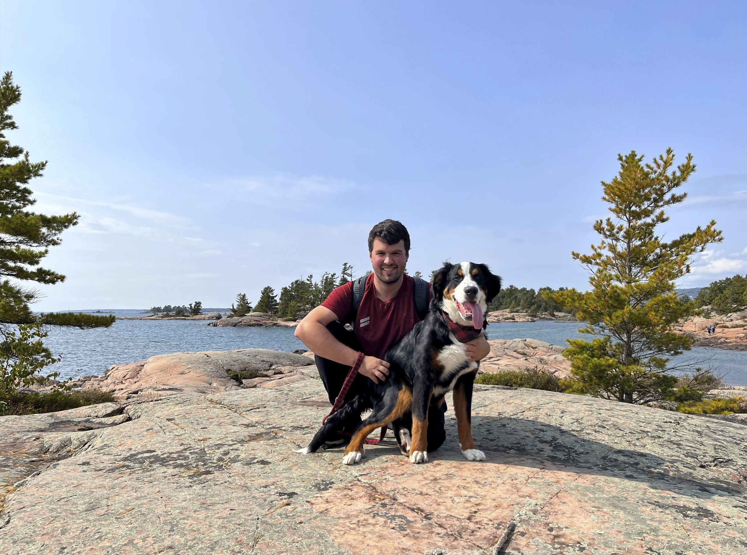 staff with dog on rocky shore