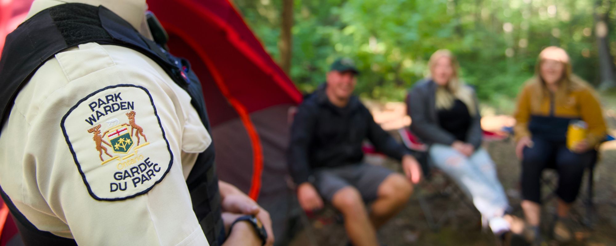 warden talking to people on campsite