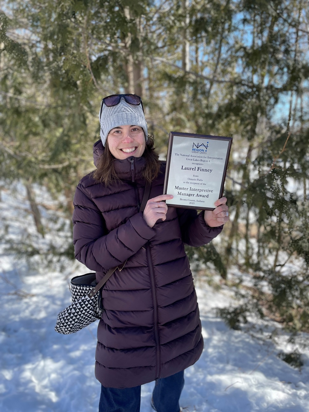 woman outdoors in winter holding plaque 