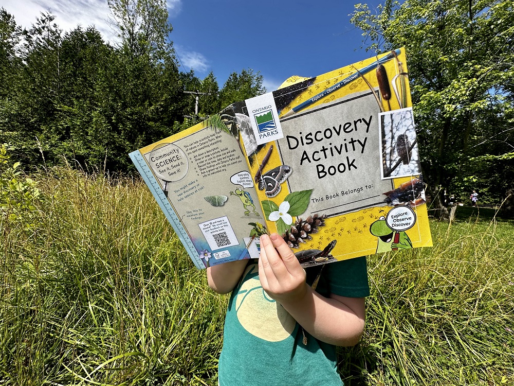 child holding discovery activity book