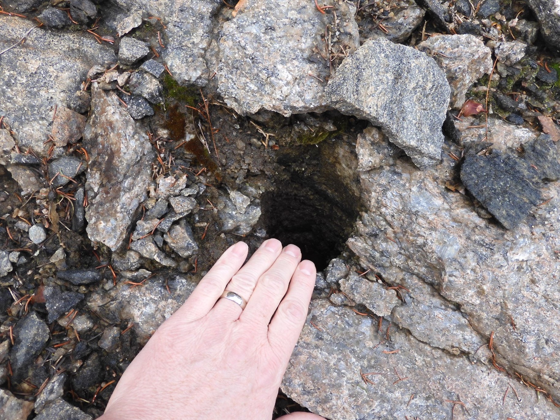 hand near hole in rock