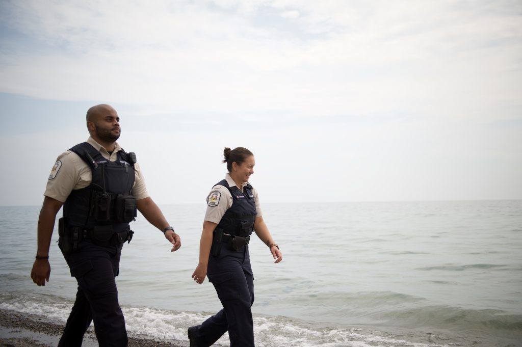 Two wardens walking on the sandy beach 