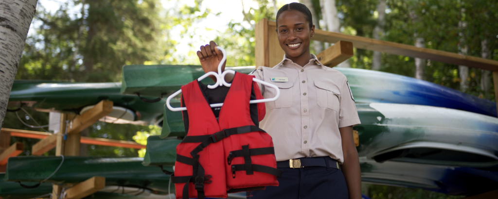 A staff member holding a red lifejacket