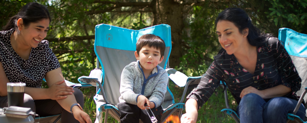 Two parents and a child enjoying a campfire