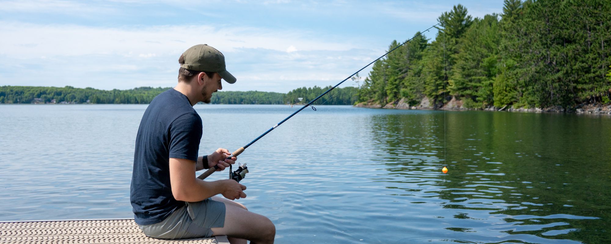 person fishing off dock into lake