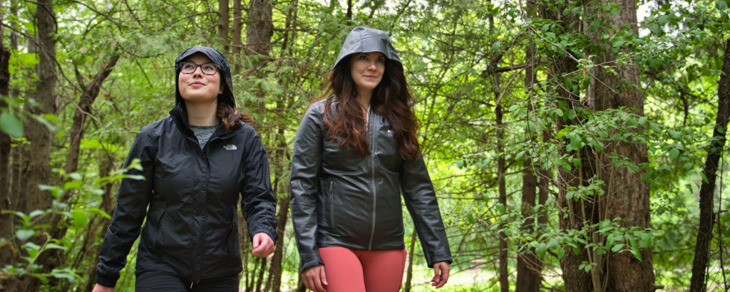 Two friends hiking trail wearing rain gear