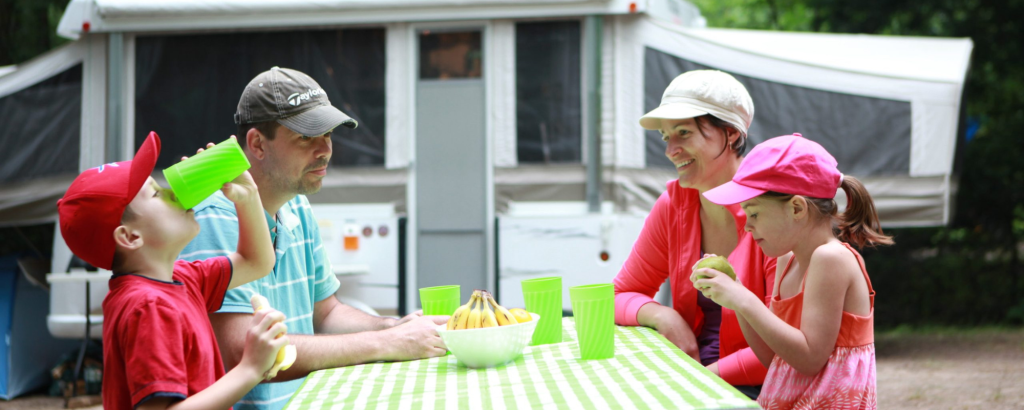 camping family eating at a picnic table