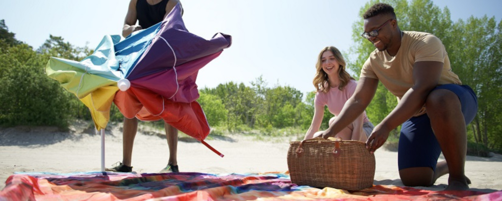 Three friends setting up a picnic on the beach