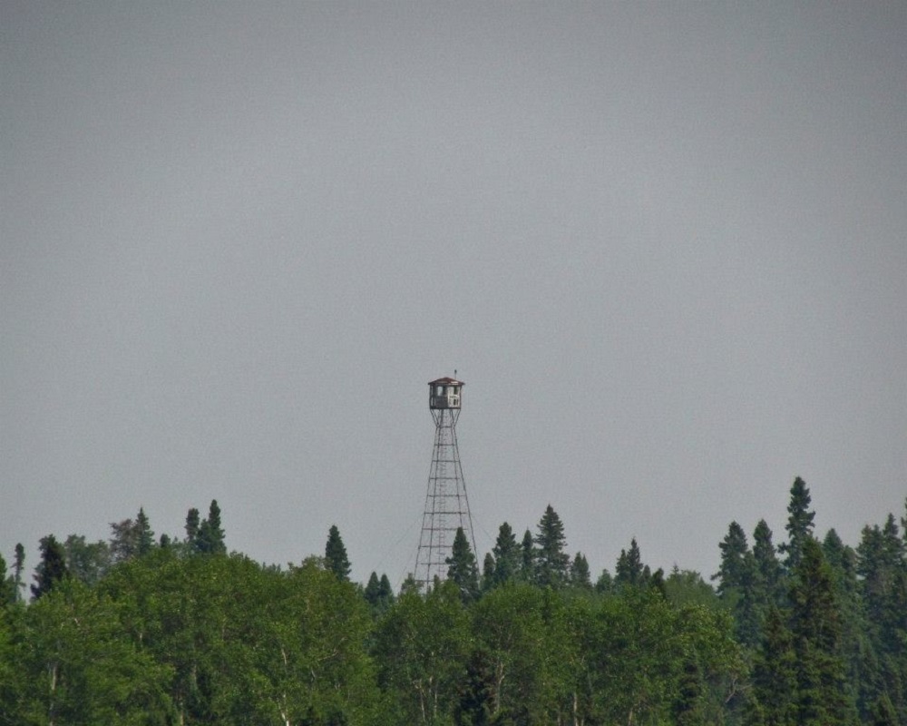 Tour de guet Bannerman à Fushimi Lake; la tour s’élève au-dessus des conifères, et le ciel est gris et brumeux