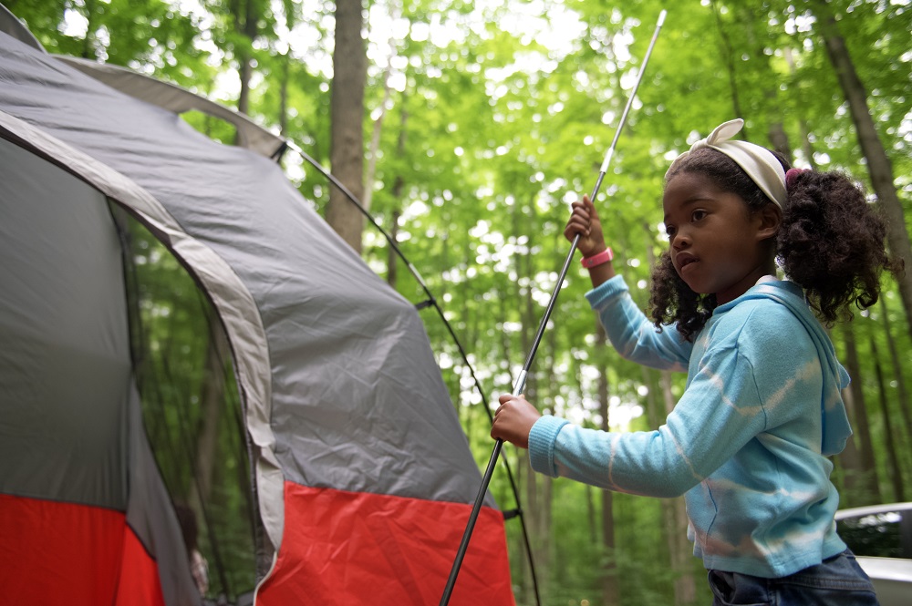 young girl setting up tent