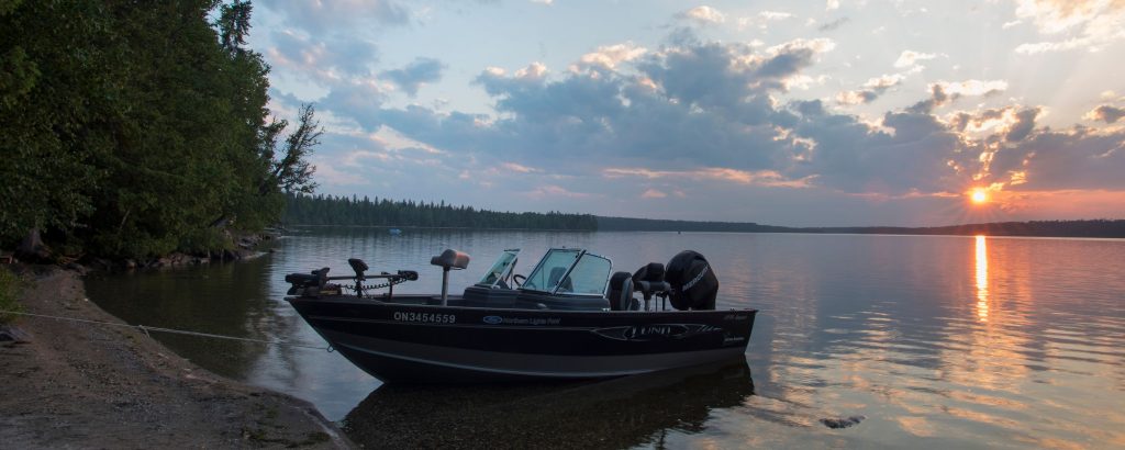 Bateau à moteur sur un lac au coucher du soleil