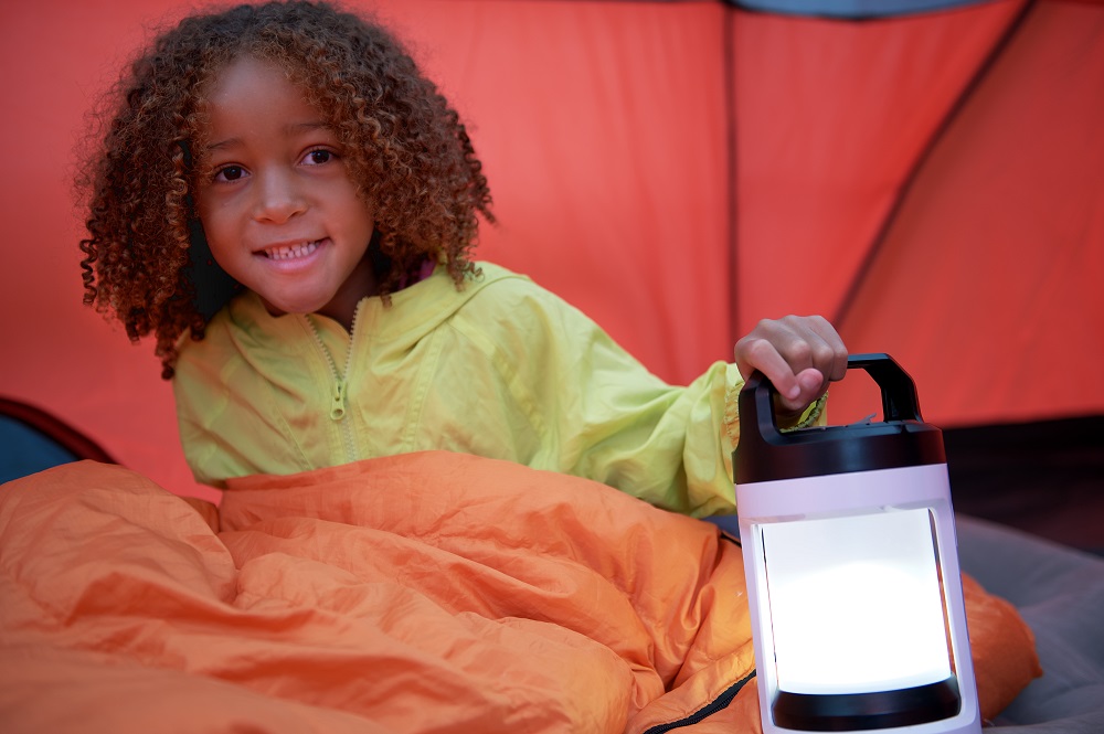 child holding lantern inside tent