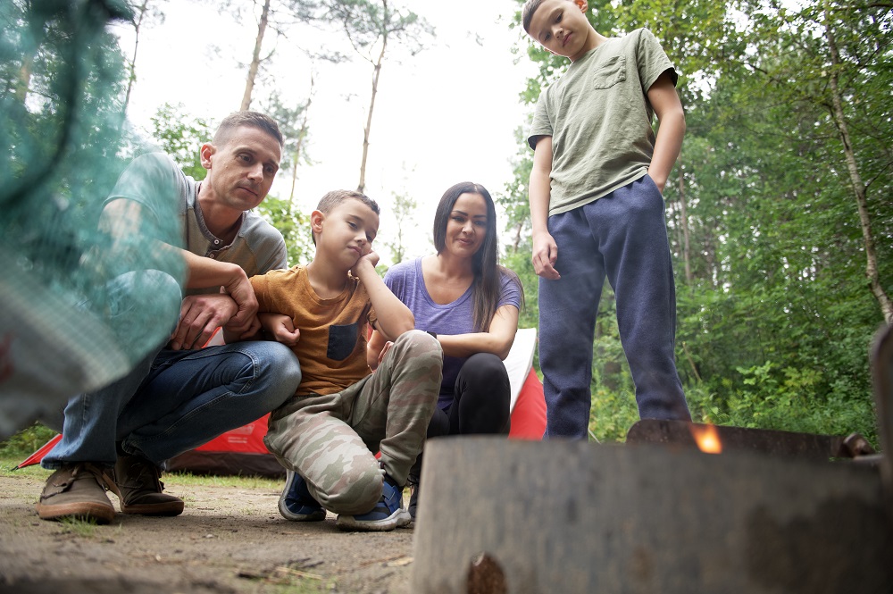 family gathering around campfire