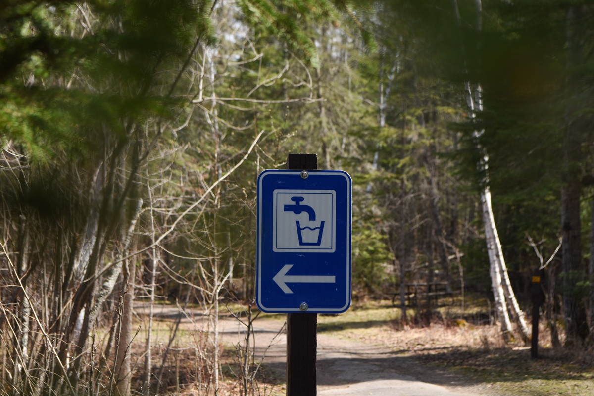 blue water tap sign in campground