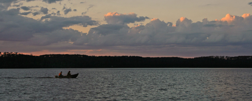 A boat on a lake at sunset
