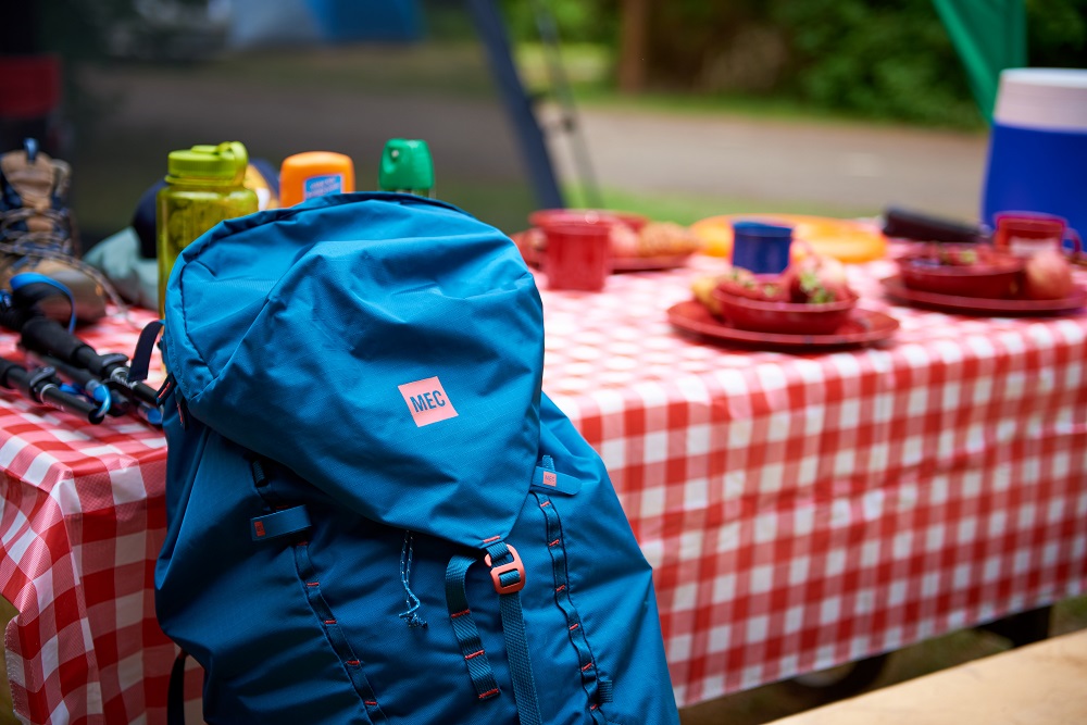 backpack on picnic table with other place settings