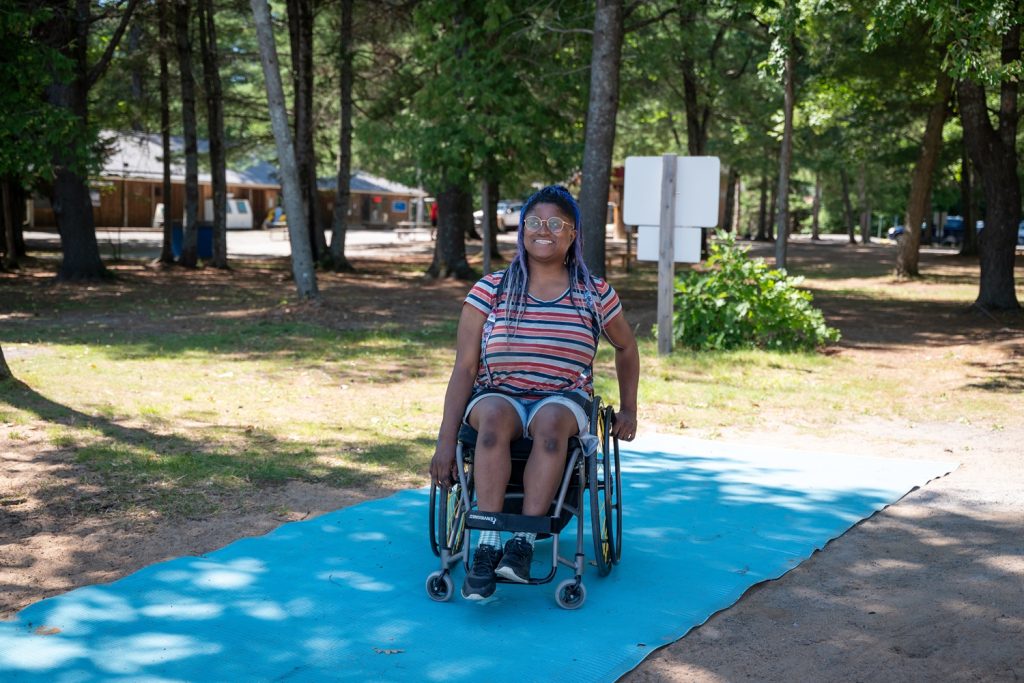 woman wheeling down beach mats