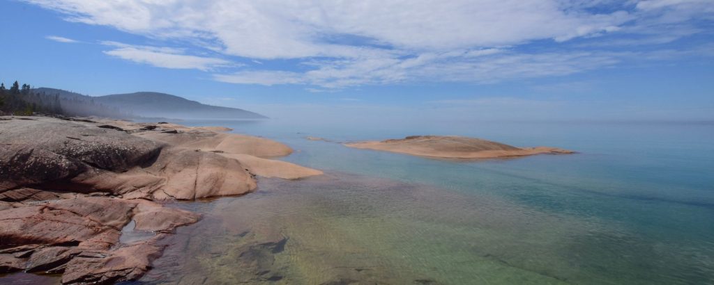 rocky shore along blue lake