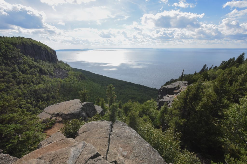 view of forest and lake from rocky lookout