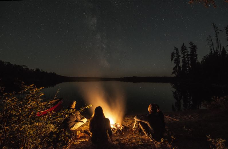 group sitting around campfire at night