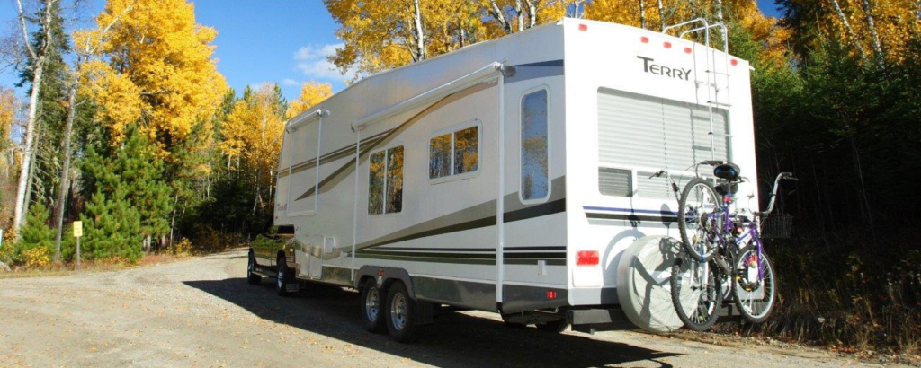 An RV parked on a road in the fall