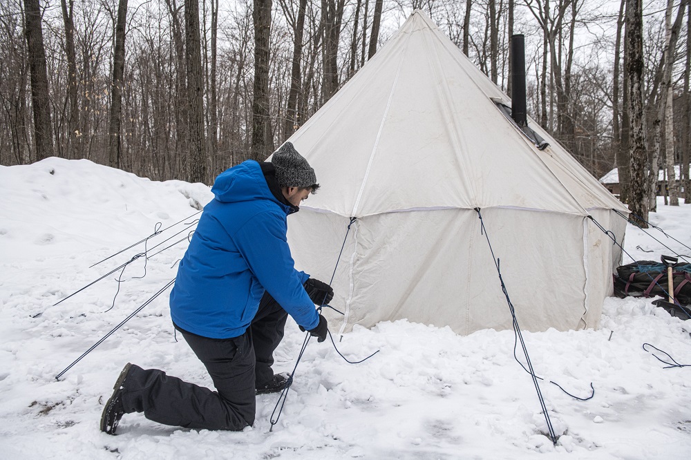 person setting up hot tent