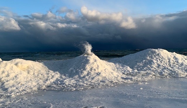 build-up of ice along the shoreline formed into the shape of a small "volcano," with icy water shooting out the top