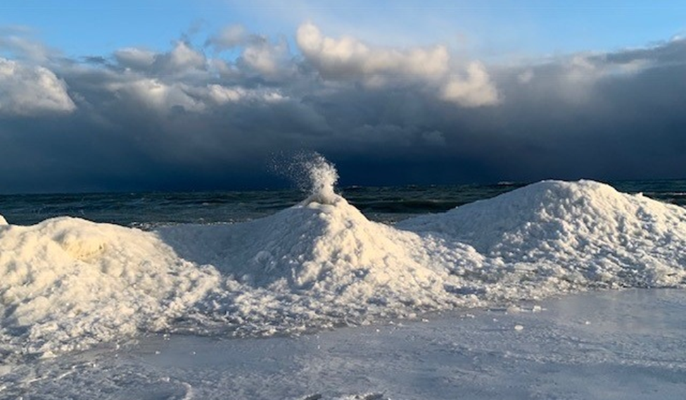 Accumulation de glace le long d’un rivage formant un petit « volcan » crachant de l’eau glacée
