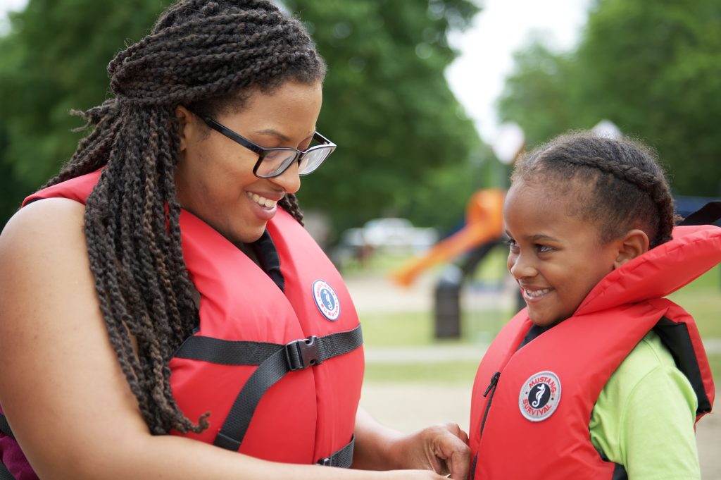 Mother putting PFD on child