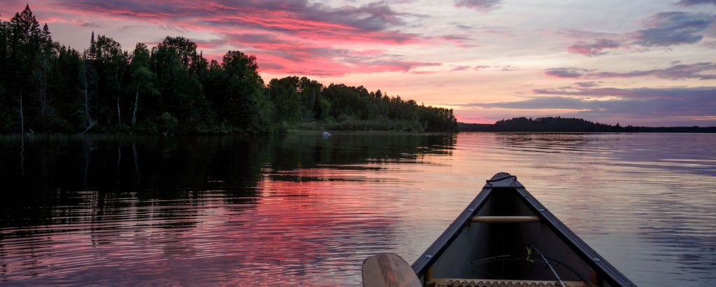 canoe with fishing rod at sunset