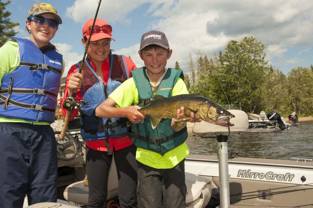 child holding fish next to mother and child