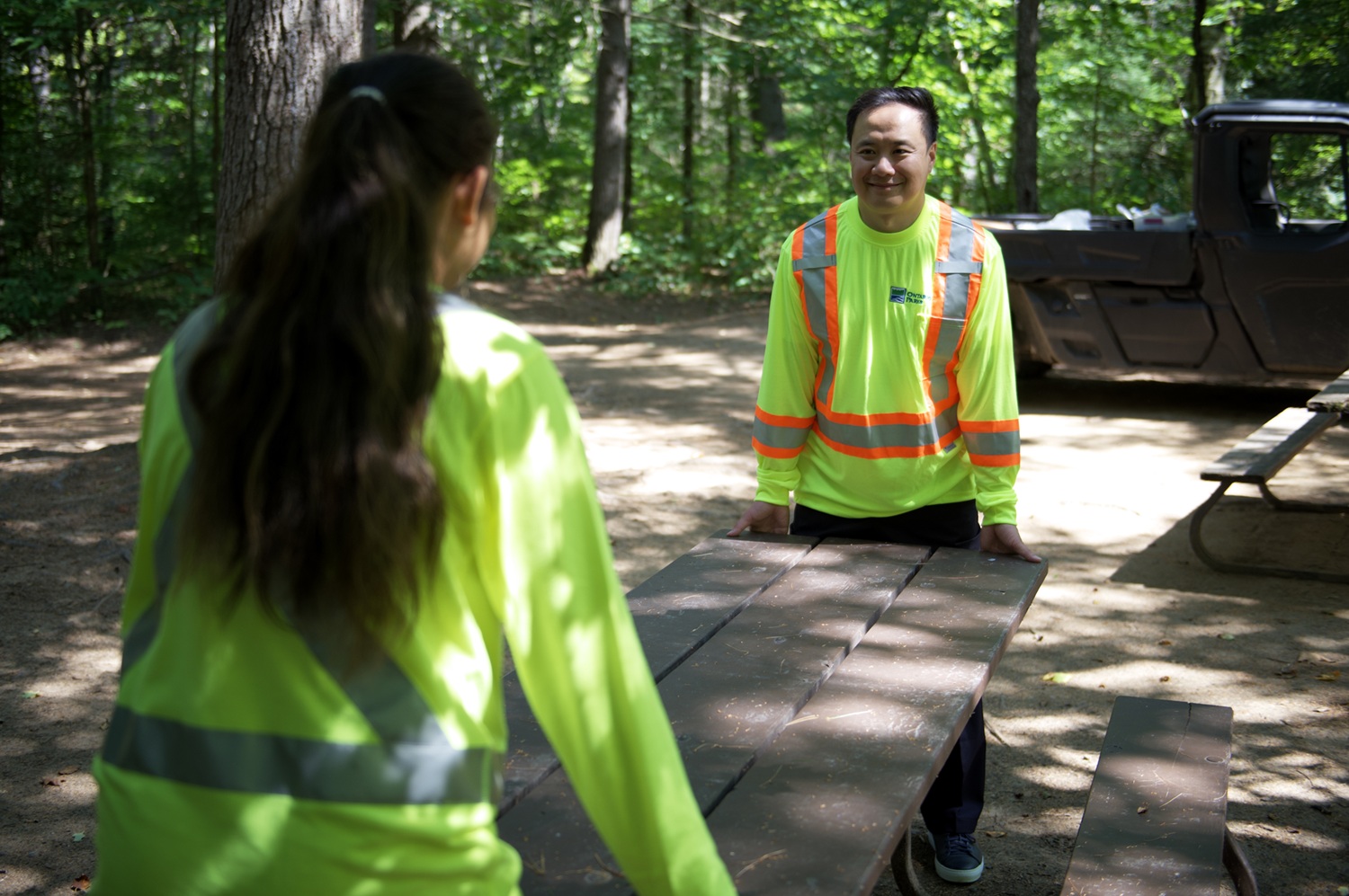 staff moving picnic table on campsite